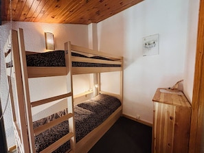 A bunk bed with a headboard, a bedside lamp, and a small wooden cabinet. - Duplex apartment, balcony with pine view - 6 guests (La Plagne Tarentaise)
