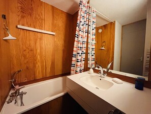 A bathroom with a wooden vanity, a white sink, a mirror, and a shower curtain. - Duplex apartment, balcony with pine view - 6 guests (La Plagne Tarentaise)