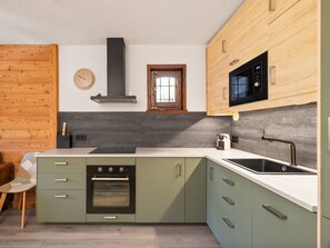A modern kitchen with a built-in oven, a microwave, and a sink. - Pleasant apartment, mountain view - 4 guests (Le Monêtier-les-Bains)