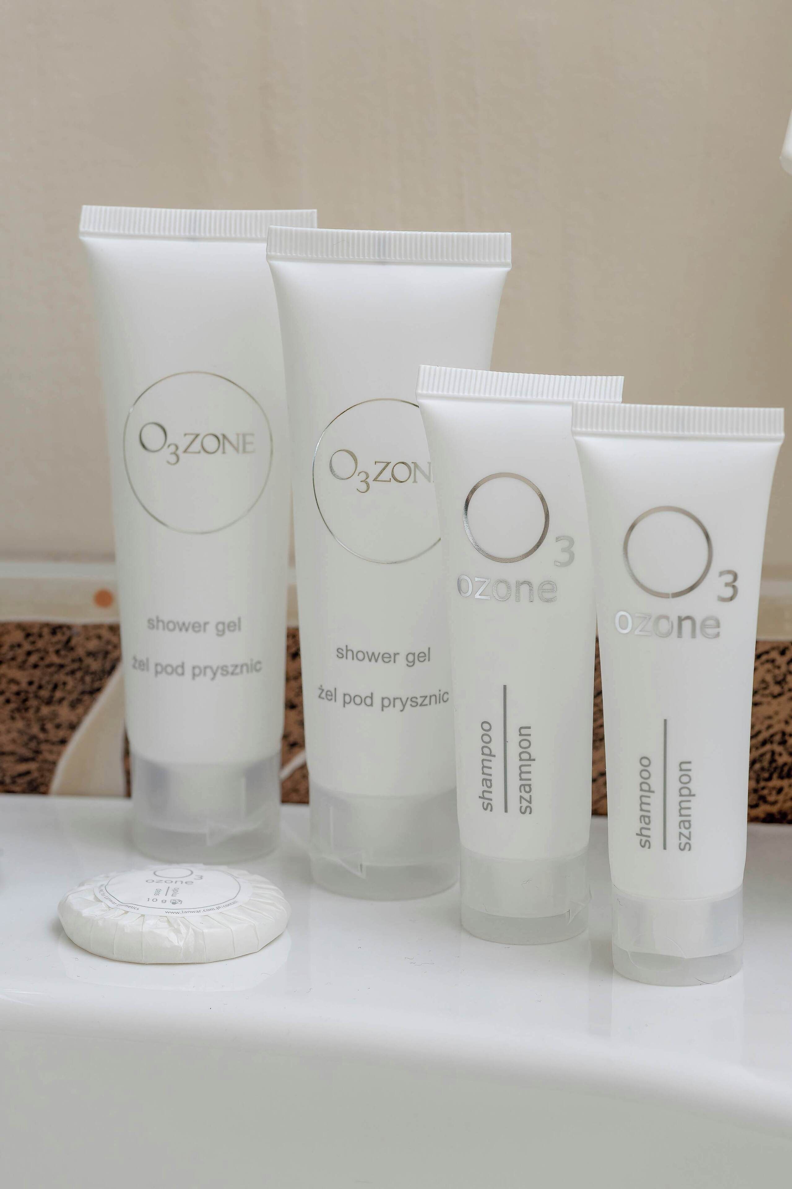 Vier Showergels von Ozone und ein rundes Produkt der Marke Ozone auf einer weißen Fläche.