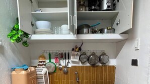 A compact kitchen with a sink, stove, and various utensils.
