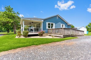 A two-story house with a covered porch, a fenced deck, and a gravel driveway. - 2-Acre Retreat Near Ocean City + Game Room (Berlin)