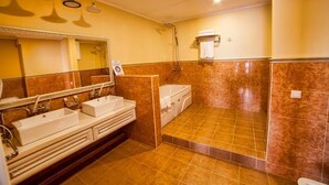 Casa de banho com duas pias, uma banheira e um chuveiro.