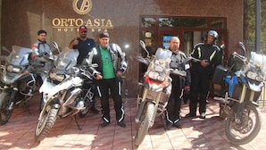 Um grupo de pessoas em frente a um edifício com uma placa que diz 'ORTO ASIA HOTEL SPA'.