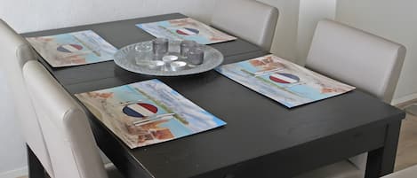 Una mesa con una bandeja de vasos y velas, rodeada de sillas.