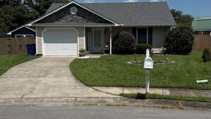 A residential house with a garage, a front yard, and a mailbox. - Timber Time (Havelock)