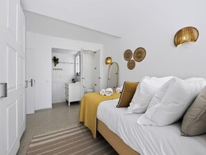 Ein modernes Schlafzimmer mit Bett, Nachttisch und Spiegel.