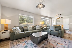 A modern living room with a sectional sofa, a coffee table, and a patterned rug.
