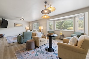 A living room with a sofa set, a coffee table, and a television mounted on the wall.
