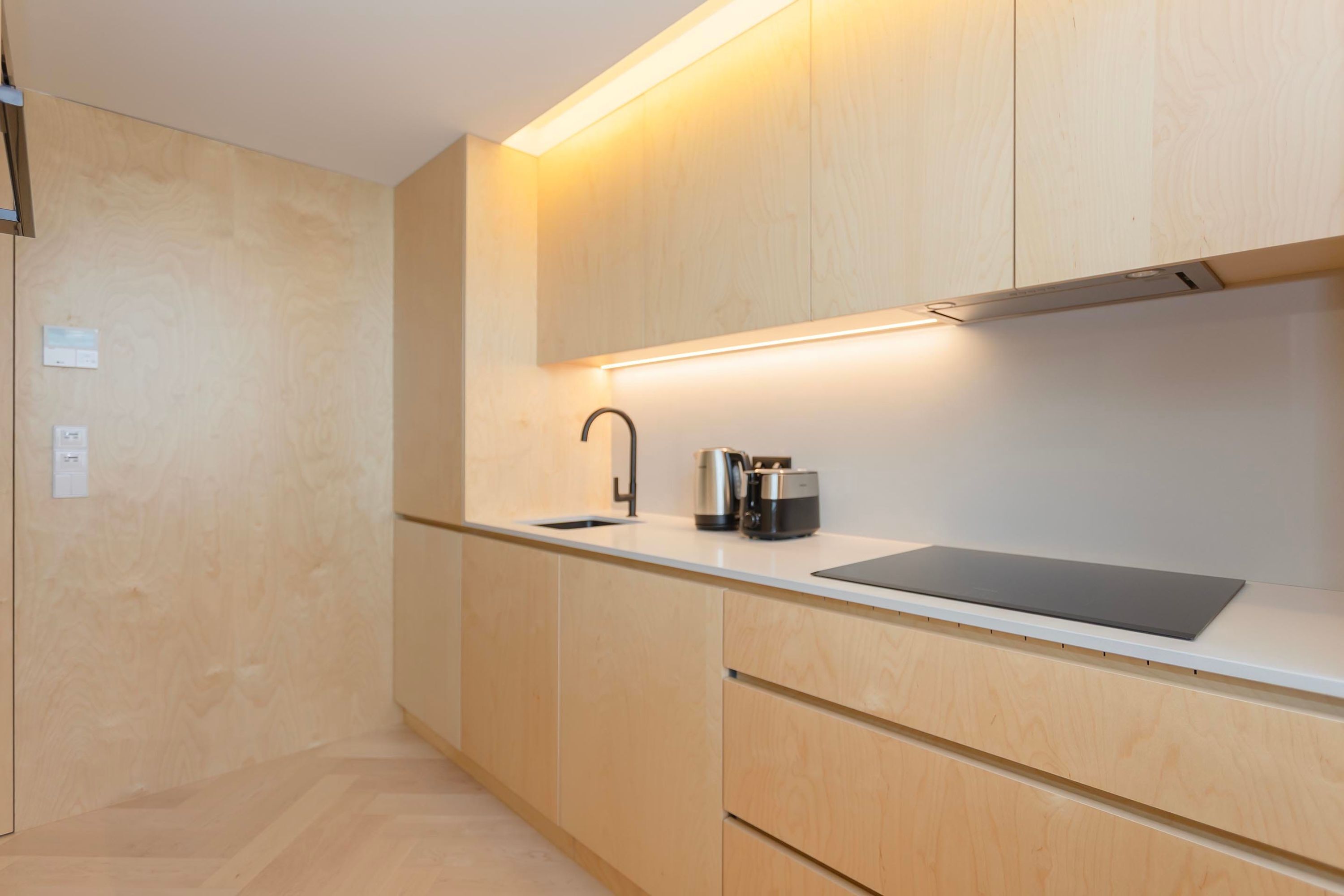 A modern kitchen with a built-in sink, stainless steel appliances, and wooden cabinetry.