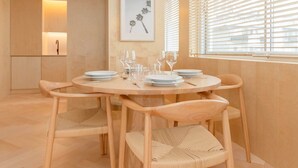 A dining area with a round table, chairs, and a hanging light fixture. - Allegro Boutique Apartment 1C by Liiiving (Porto)