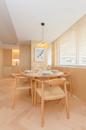 A dining area with a round table, chairs, and a hanging light fixture. - Allegro Boutique Apartment 1C by Liiiving (Porto)