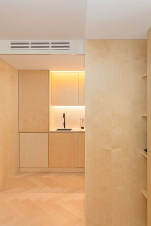A modern kitchen with wooden cabinets, a stainless steel sink, and a built-in range hood. - Allegro Boutique Apartment 1C by Liiiving (Porto)
