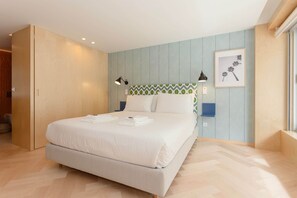 Ein Hotelzimmer mit einem Bett, Nachttischlampen, einem gerahmten Bild an der Wand und einem Fenster.