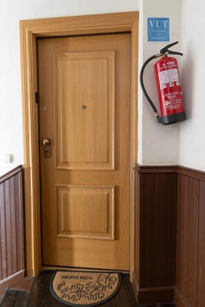 Eine Holztür mit Knauf und Fußmatte, auf der 'BIENVENIDO' steht.