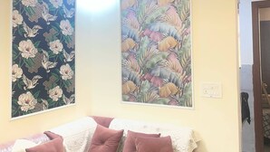 Ein Zimmer mit einem Bett, zwei an der Wand befestigten Bildern und einem Deckenventilator.