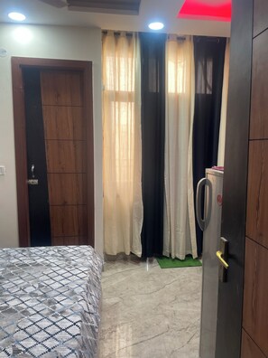 A bedroom with a bed, a wardrobe, and a door leading to another room.