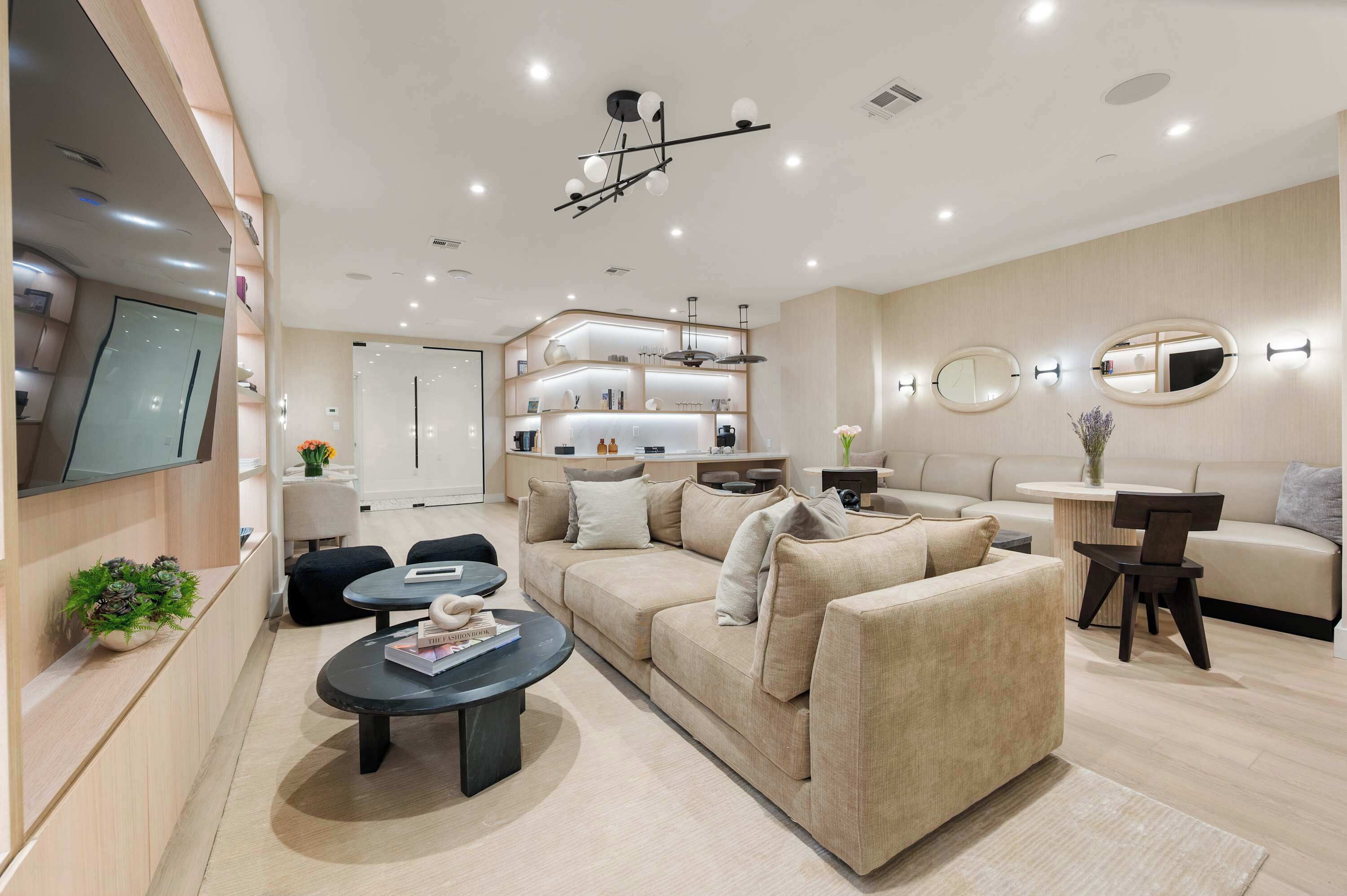 A modern living room with a sofa, coffee table, and a TV mounted on the wall.