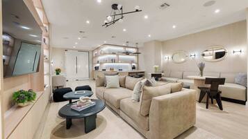 A modern living room with a sofa, coffee table, and a TV mounted on the wall.