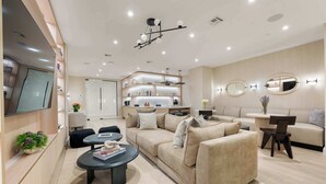 Una sala de estar moderna con sofá, mesa de centro y televisor montado en la pared.