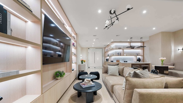 A modern living room with a sofa, coffee table, and shelves. - 17john: 3 Bed Private Terrace W/D in Unit + GYM (New York)