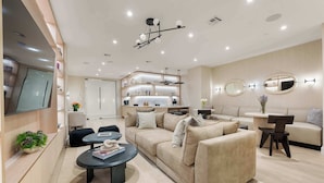Ein modernes Wohnzimmer mit einer Couch, einem Couchtisch und einem an der Wand befestigten Fernseher.