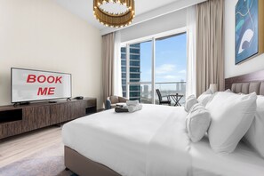 A hotel room with a large bed, a television, a desk, and a view of the cityscape. - Stayshort - Dubai Media City Sleeps 2 With Amazing Sea Views (Dubai)
