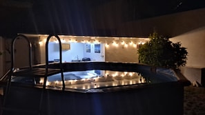 Un bain à remous avec vue sur un coin cuisine, comprenant un évier et une fenêtre.