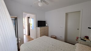A bedroom with a bed, a dresser, a television on top, and a door. - Holiday Home 'Casa Con Encanto Junto A La Playa' with Private Pool, Wi-Fi and Air Conditioning (El Puerto de Santa María)