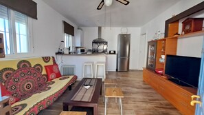 A modern living room with a sofa, coffee table, and TV stand. - Holiday Home 'Casa Con Encanto Junto A La Playa' with Private Pool, Wi-Fi and Air Conditioning (El Puerto de Santa María)