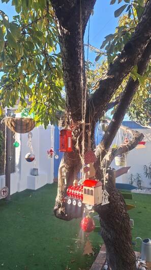 A tree with various decorations including a red lantern, a miniature train, and hanging ornaments. - Holiday Home 'Casa Con Encanto Junto A La Playa' with Private Pool, Wi-Fi and Air Conditioning (El Puerto de Santa María)