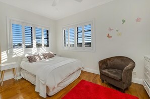 Une chambre à coucher avec un lit, un bureau, une chaise et un tapis rouge.