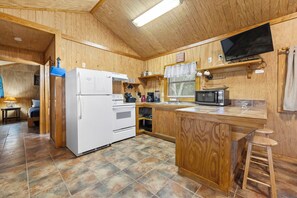 A compact kitchen with a refrigerator, microwave, and sink. - Casita: 1  BR, 1  BA House in Concan, Sleeps 4 (Concan)