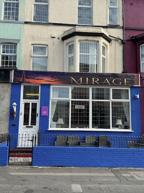 A hotel named 'MIRAGE' with a blue facade, large windows, and a sign indicating vacancies. - MIRAGE HOTEL (Blackpool)