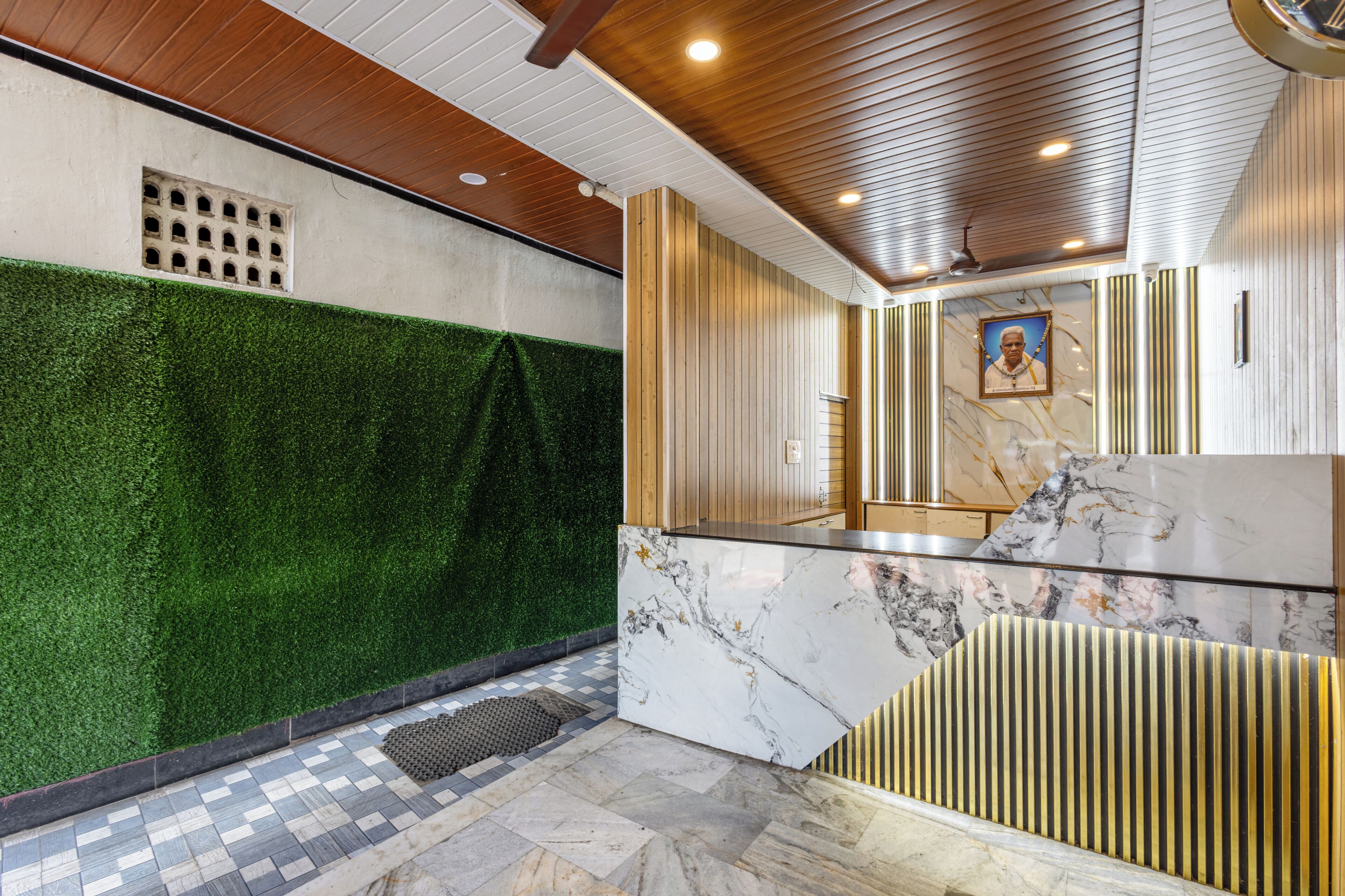 A lobby with a green wall, marble flooring, and a wooden ceiling.