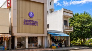 A building with a sign for 'Srinivasa Residency' and a 'ROOMS' sign on the left. - Srinivasa Residency - SVGMC (Tirupati)