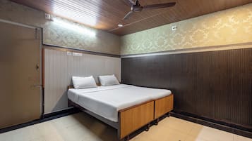 A bedroom with a bed, a wardrobe, a ceiling fan, and a patterned wall.