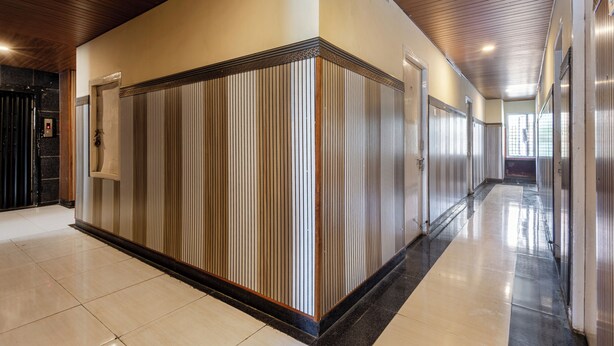 A hallway with a striped wall, a door, and a light fixture on the ceiling. - Srinivasa Residency - SVGMC (Tirupati)