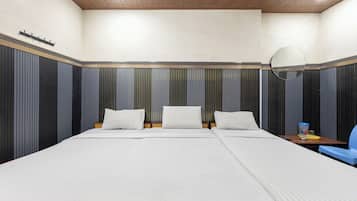 Habitación de hotel con una cama grande, una mesita de noche, una silla y un espejo.
