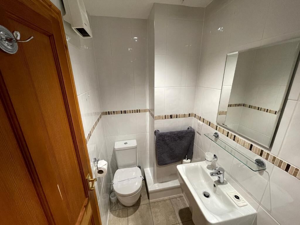 Un baño con inodoro, lavamanos y espejo.