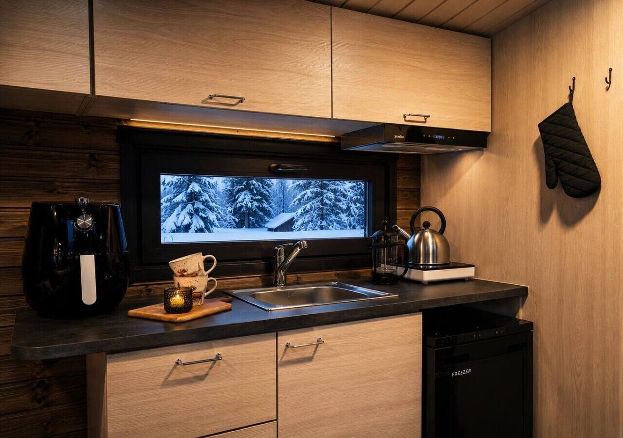 Una cocina moderna con televisor integrado, electrodomésticos de acero inoxidable y armarios de madera.