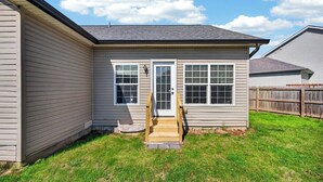A single-story house with a front door, two windows, and a small porch. - Roadmap Lodging: Sumpter Stay, 3BR Monthly, Garage, Fenced Yard, Pet OK (Columbus)