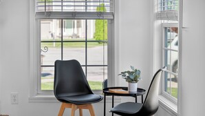 A room with a modern chair, a small table, and a potted plant. - Roadmap Lodging: Sumpter Stay, 3BR Monthly, Garage, Fenced Yard, Pet OK (Columbus)