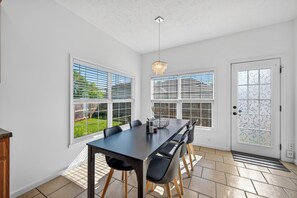 A dining area with a table, chairs, and a chandelier. - Roadmap Lodging: 3BR + Garage Near Regional Health (Columbus)