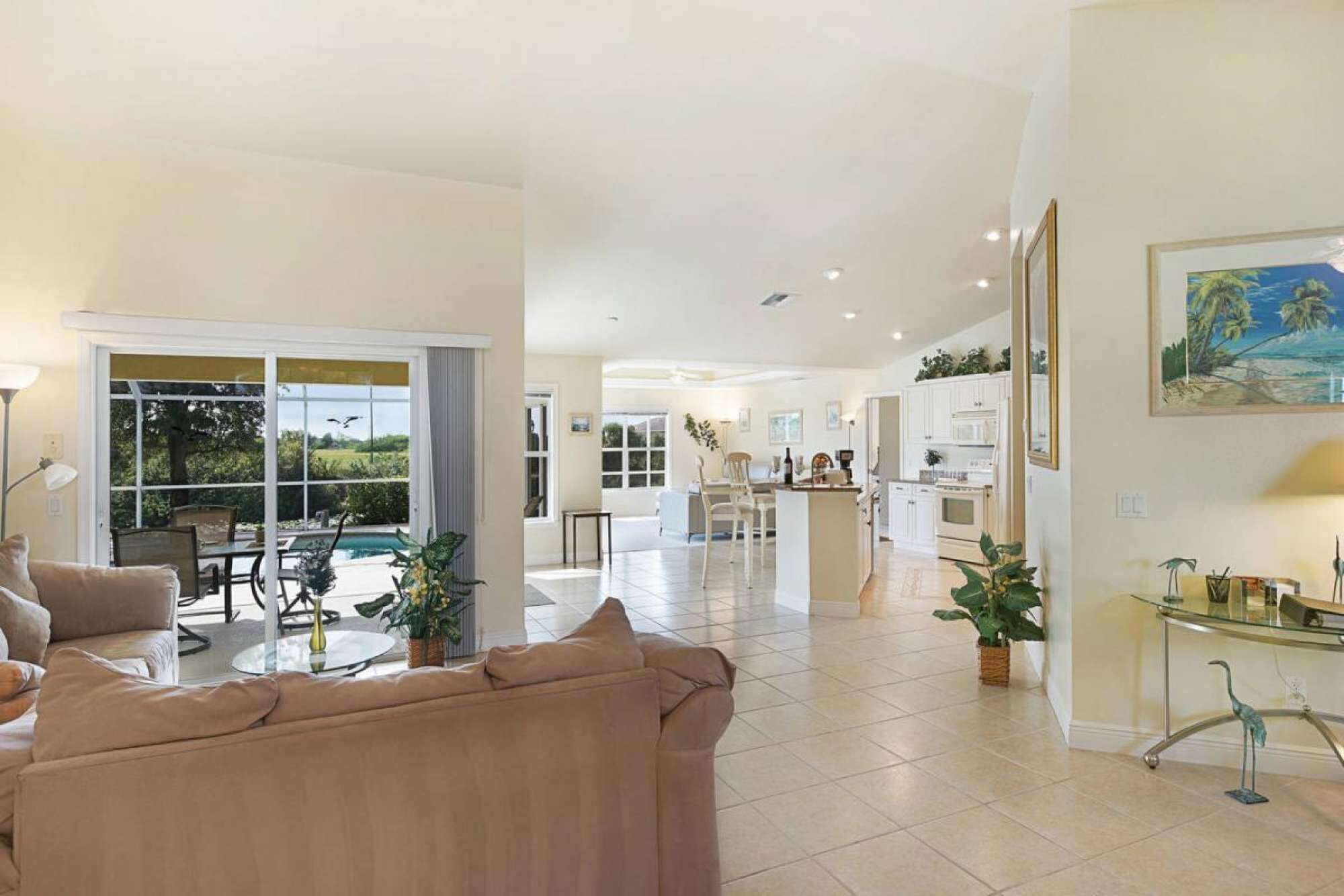 A spacious living area with a large sofa, a dining table, and a kitchen in the background.
