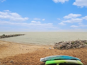 A sandy beach with calm water, a clear sky, and a rocky outcrop. - Beautiful Breakers East Condo with Lake Michigan Views (Harbor Springs)