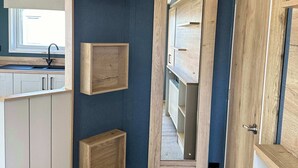 A modern kitchen with built-in wooden cabinets, a central island, and a window with a view. - Kielder - Spacious 3 Bed, Luxury Lodge, Haven, Seton Sands (Port Seton)