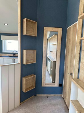 A modern kitchen with built-in wooden cabinets, a central island, and a window with a view. - Kielder - Spacious 3 Bed, Luxury Lodge, Haven, Seton Sands (Port Seton)