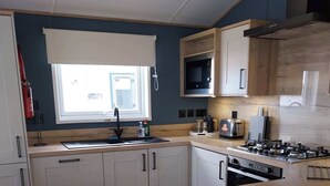 A modern kitchen with a central island, built-in microwave, and stainless steel appliances. - Kielder - Spacious 3 Bed, Luxury Lodge, Haven, Seton Sands (Port Seton)