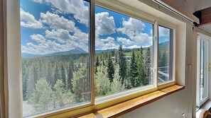 A room with large windows offering a view of a forested mountain area. - NEW! Cozy escape with breathtaking treetop views (Silverthorne)